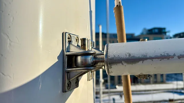 Nærbilde av metallhengsel og bolt på en båtdør eller luke.